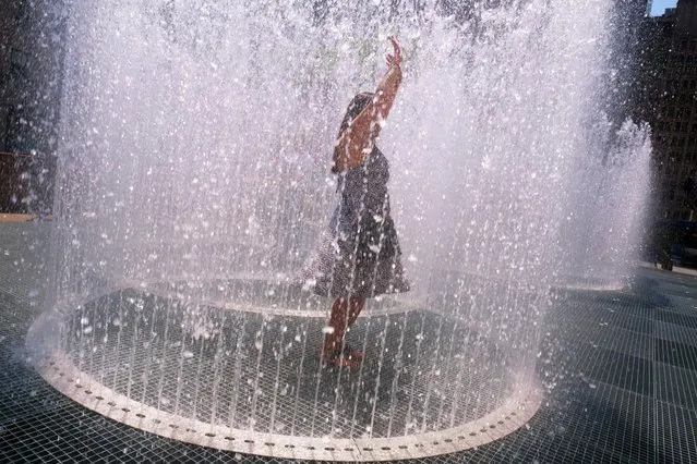 Woman stands inside water fountain art installation, “Changing Spaces” by Jeppe Hein at Rockefeller Center in New York on July 12, 2022. (Photo by Edna Leshowitz/ZUMA Press Wire/Rex Features/Shutterstock)