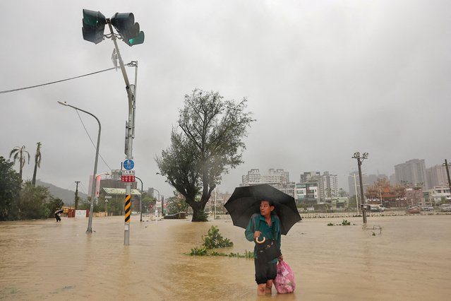 A person looks on as he wades through the floodwaters to work after Typhoon Krathon made landfall in Kaohsiung, Taiwan on October 3, 2024. (Photo by Ann Wang/Reuters)
