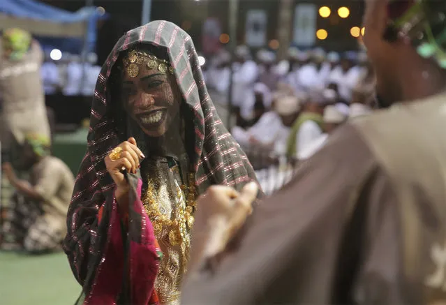 In this August 4, 2017 photo, members of a dance troupe, in traditional garb, perform during a festival celebrating the monsoon season, in Salalah, southern Oman. The 60-day festival of dance competitions, concerts, exorcisms performed by Sufis and the moderate temperatures draws tens of thousands of tourists to the region each year. (Photo by Sam McNeil/AP Photo)