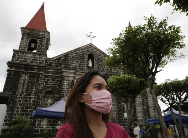 A woman wearing a protective mask walks outside a church in Mandaluyong, east of Manila, Philippines on Sunday, February 2, 2020. The Philippines on Sunday reported the first death of a new virus outside of China, where authorities delayed the opening of schools in the worst-hit province and tightened quarantine measures in another that allow only one family member to venture out to buy supplies. (Photo by Aaron Favila/AP Photo)