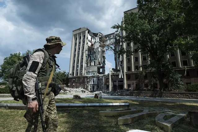 A Ukrainian serviceman stands in front of headquarters of the Mykolaiv Regional Military Administration building destroyed by a Russian attack in Mykolaiv, Ukraine, Friday, August 5, 2022. (Photo by Evgeniy Maloletka/AP Photo)