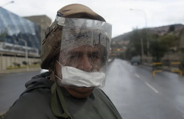 A soldier patrols an empty road amid government restrictions that limit residents, based on their national ID number, to essential shopping in the morning in an attempt to contain the spread of the new coronavirus in La Paz, Bolivia, Monday, March 30, 2020. COVID-19 causes mild or moderate symptoms for most people, but for some, especially older adults and people with existing health problems, it can cause more severe illness or death. (Photo by Juan Karita/AP Photo)