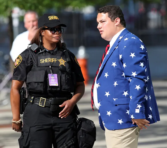A Cuyahoga County Sheriff  helps give directions to a man dressing in stars and strips during the Republican National Convention in Cleveland, Ohio, U.S. July 21, 2016. (Photo by Aaron Josefczyk/Reuters)