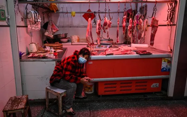A meat vendor wearing a face mask waits for a customer at a market in Wuhan, on April 2, 2020. Wuhan, the central Chinese city where the coronavirus first emerged last year, partly reopened on March 28 after more than two months of near total isolation for its population of 11 million. (Photo by Hector Retamal/AFP Photo)
