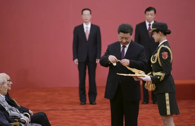 China's President Xi Jinping holds a commemorative medal before presenting to veterans at a medal ceremony marking the 70th anniversary of the Victory of Chinese People's War of Resistance Against Japanese Aggression, for World War Two veterans, at the Great Hall of the People in Beijing, China September 2, 2015. (Photo by Jason Lee/Reuters)