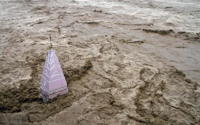 A temple stands amid the waters of the overflowing river Tawi during heavy rains in Jammu September 6, 2014. Authorities declared a disaster alert in the northern region after heavy rain hit villages across the Kashmir valley, causing the worst flooding in two decades. (Photo by Mukesh Gupta/Reuters)