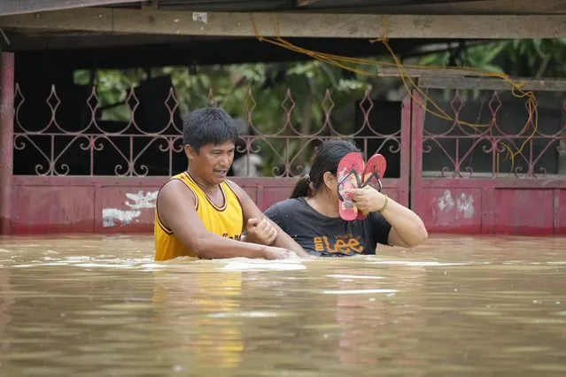 Residents negotiate a flooded road due to Typhoon Noru in San Miguel town, Bulacan province, Philippines, Monday, September 26, 2022. (Photo by Aaron Favila/AP Photo)