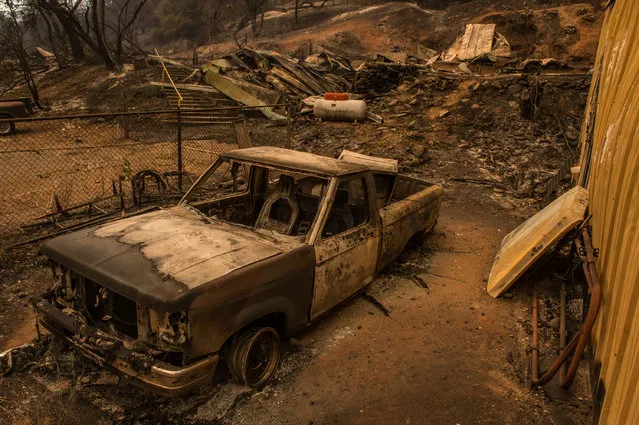 Burnt remains of a vehicle left behind remains off Jesus Maria Road near Mokelumne Hill, Calif., Friday, September 11, 2015. The wildfire in Northern California that exploded in size has destroyed multiple homes in Amador County as evacuations remained in place Thursday, Cal Fire officials said. (Photo by Andrew Seng/The Sacramento Bee via AP Photo)