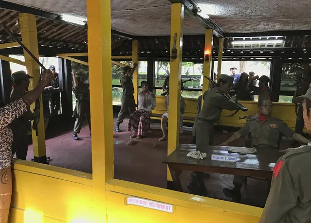In this Sunday, October 15, 2017, photo, visitors look at a diorama depicting the torture and killing of six army generals and a junior officer in an abortive coup in 1965 that the military blamed on Indonesia's Communist Party and subsequently led to the anti-communist purge in 1965-1966, at Pancasila Sakti Monument in Jakarta, Indonesia. Declassified files have revealed new details of American government knowledge and support of an Indonesian army extermination campaign that killed several hundred thousand civilians during anti-communist hysteria in the mid-1960s. (Photo by Dita Alangkara/AP Photo)