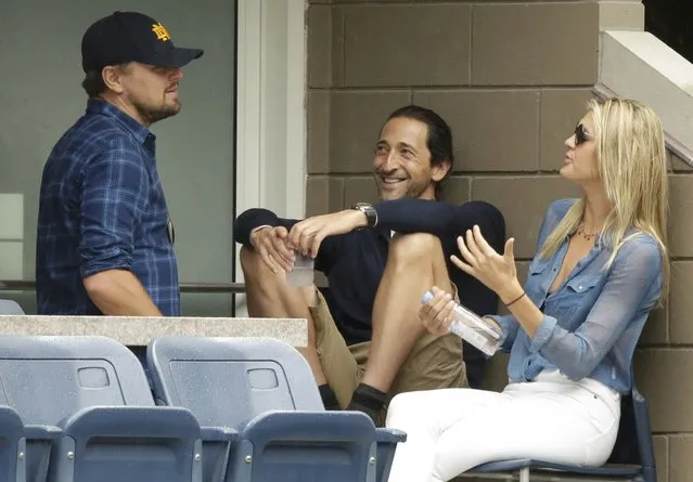 American actors Leonardo DiCaprio (L) and Adrien Brody chat as they wait out a rain delay while attending the men's singles final match between Roger Federer of Switzerland and Novak Djokovic of Serbia at the U.S. Open Championships tennis tournament in New York, September 13, 2015. (Photo by Lucas Jackson/Reuters)