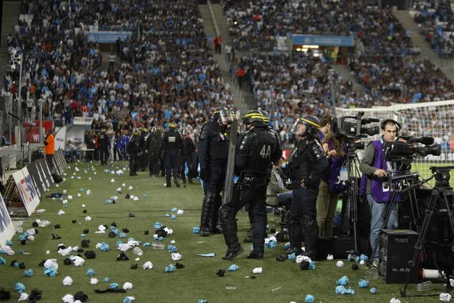 Police intervene during the French Ligue 1 soccer match between Olympique Marseille and Olympique Lyon at the Velodrome Stadium in Marseille, France, September 20, 2015. French Sports minister called for tougher security measures in French stadium after crowd trouble interrupted a Ligue 1 game at Marseille's Stade Velodrome on Sunday. The match was interrupted for 23 minutes after fans threw glass bottles onto the pitch. (Photo by Philippe Laurenson/Reuters)