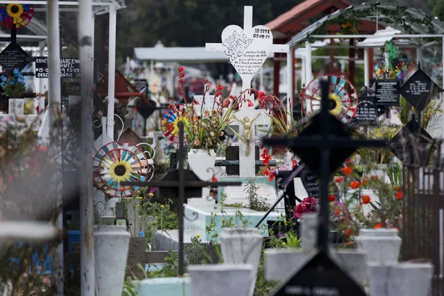 In this Oct. 14, 2014 photo, graves decorated with flowers and signposts stand tightly packed together at the nearly-full San Isidro cemetery in northern Mexico City. With cemeteries rapidly reaching capacity in one of the world's biggest cities, families are forced to exhume and remove their relative's remains after a period of several years. (AP Photo/Rebecca Blackwell)