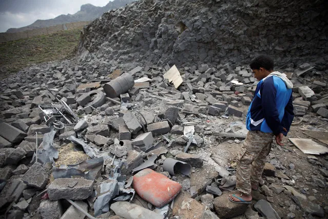 A youth looks at rubble of a house after it was destroyed by a Saudi-led air strike in Yemen's capital Sanaa, August 11, 2016. (Photo by Mohamed al-Sayaghi/Reuters)