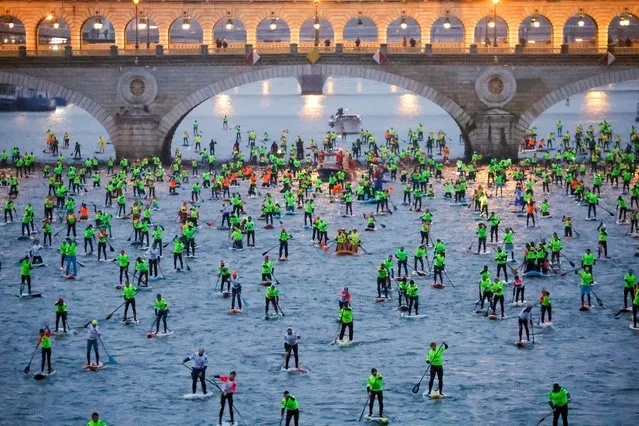 Participants start in the 12th Edition of the Nautic SUP Paris Crossing stand up paddle competition on the river Seine in Paris, France on December 4, 2022. (Photo by Pascal Rossignol/Reuters)