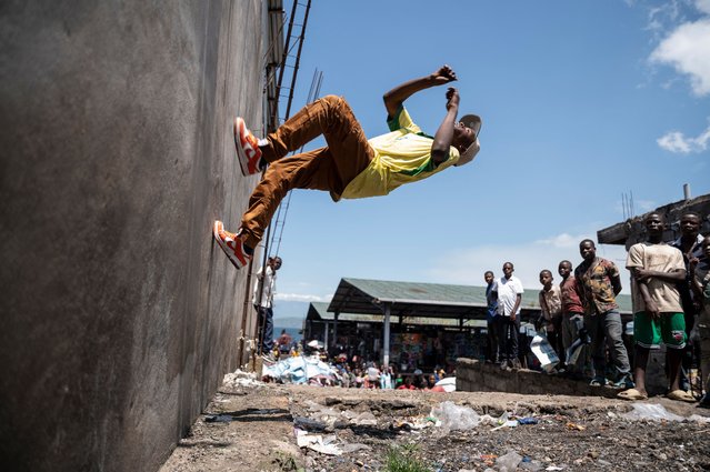 A breakdancer from the Congo Street collective performs at the Kituku market port in Goma on April 3, 2025. Drawing inspiration from breakdance and hip-hop, while incorporating their unique style, the collective's transform these space into a vibrant stage, captivating the audience with their energy and mastery of urban dance. (Photo by Jospin Mwisha/AFP Photo)