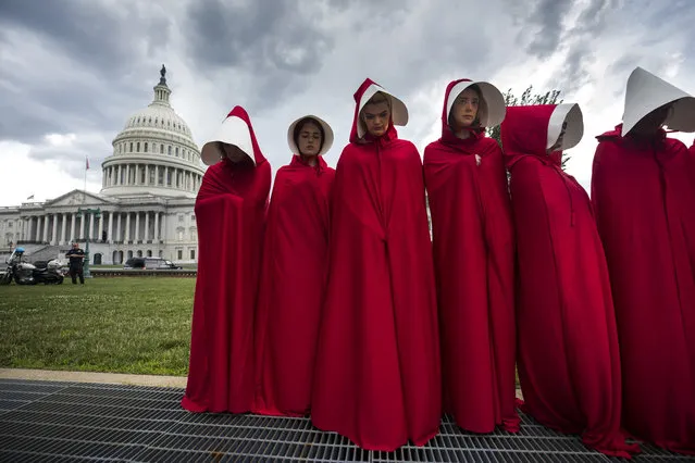 Supporters of Planned Parenthood dress in costumes from the dystopian novel The Handmaid's Tale to protest the Senate Republican's health care bill outside the US Capitol in Washington, DC, USA, 27 June 2017. Earlier in the afternoon, with five Republican Senators saying they would not vote for the bill, Republican Majority Leader Mitch McConnell announced he would not put the bill to the floor for a vote. (Photo by Jim Lo Scalzo/EPA/EFE)