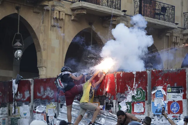 Anti-government protesters use fireworks against Lebanese riot police during a protest in the aftermath of last Tuesday's massive explosion which devastated Beirut, Lebanon, Monday, August 10, 2020. (Photo by Hassan Ammar/AP Photo)
