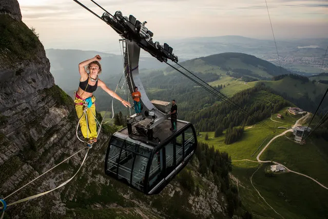 Lenoble, 25 walks a slackline between two cable cars on the mountain of Moleson in Switzerland. (Photo by Martin Knobel/Caters News Agency)