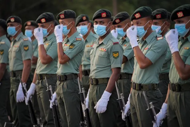 An honor guard wearing face masks to help curb the spread of the coronavirus waits for the start of National Day rehearsals in Putrajaya, Malaysia, Friday, August 28, 2020. Federation of Malaya gained its independence from Britain on Aug. 31 in 1957. (Photo by Vincent Thian/AP Photo)