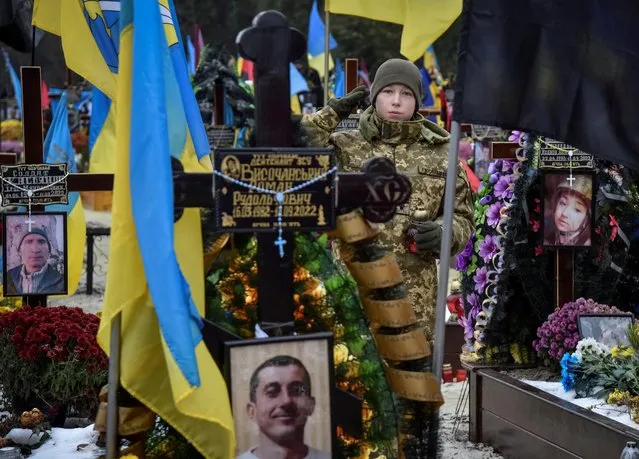 A military cadet visits graves of Ukrainian servicemen who were killed during Russia's attack of Ukraine, on the Day of Ukrainian Army at the Lychakiv cemetery in Lviv, Ukraine on December 6, 2022. (Photo by Pavlo Palamarchuk/Reuters)