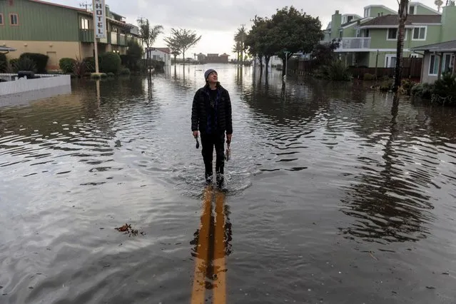 A resident walks along a flooded street, after “atmospheric river” rainstorms slammed northern California, in the coastal town of Aptos, U.S., January 5, 2023. (Photo by Carlos Barria/Reuters)