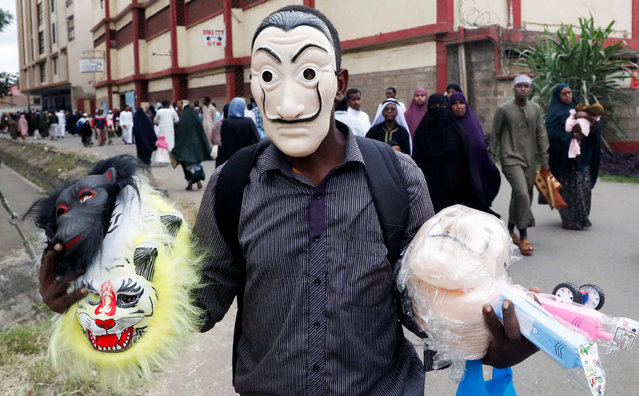 A vendor wears a face mask as he carries others for sale, as Muslims leave after prayers on the first day of the Muslim holiday of Eid al-Adha, outside the Sir Ali Muslim Club Ground in Ngara district of Nairobi, Kenya, on June 6, 2025. (Photo by Monicah Mwangi/Reuters)