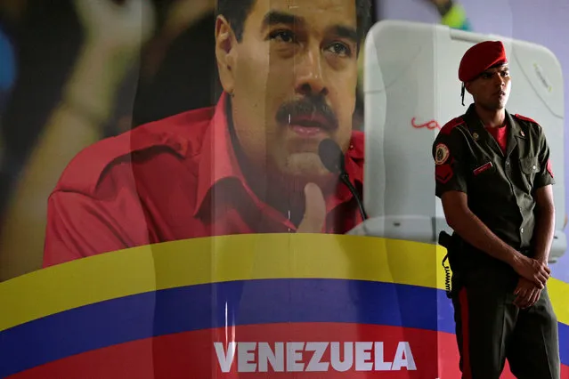 A soldier stands guard next to a portrait of Venezuela's President Nicolas Maduro at the International Press Center of the 17th Non-Aligned Summit in Porlamar, Venezuela September 15, 2016. (Photo by Marco Bello/Reuters)