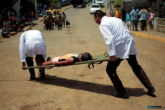 Civil defence members carry a participant playing the role of a victim during a national multi-hazard drill organized by the National System for Prevention, Mitigation and Attention to Disasters (SINAPRED), in the 30 de Mayo neighborhood in Managua, Nicaragua, September 26, 2016. (Photo by Oswaldo Rivas/Reuters)