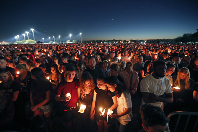 People attend a candlelight vigil for the victims of the Wednesday shooting at Marjory Stoneman Douglas High School, in Parkland, Fla., Thursday, February 15, 2018. Nikolas Cruz, a former student, was charged with 17 counts of premeditated murder on Thursday. (Photo by Gerald Herbert/AP Photo)