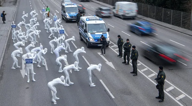 Greenpeace activists wear white morphsuits as they stage an action against particulate matter and health burden caused by diesel exhaust on February 19, 2018 in Stuttgart, southern Germany. A verdict of Germany's Federal Administrative Court is expected on February 22, 2018, ruling if cities with high nitrogen oxide pollution could be allowed to ban diesel cars from their centres. (Photo by Sebastian Gollnow/AFP Photo/DPA)