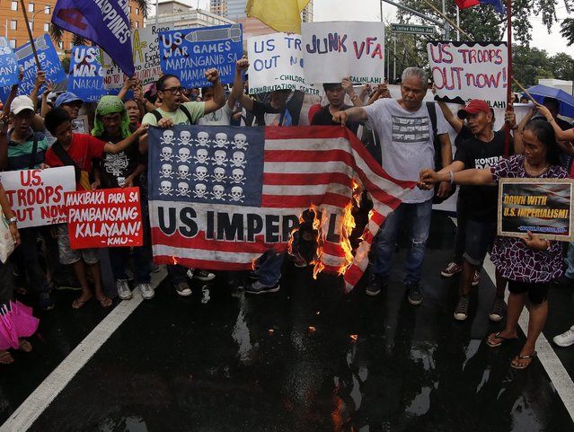 Filipino militant groups burn a US flag during a demonstration against the on-going US-Philippines military exercises in front of the US Embassy in Manila, Philippines, 04 October 2016. The protesting groups said that they support President Rodrigo Ruderte's statement to stop future US-Philippines military exercises. President Rodrigo Duterte said in a statement that the on-going joint military exercise between the Philippines and the United States will be the last under his term. The bilateral exercise aims to enhance the inter-operability across different military operations including humanitarian assistance and disaster response operations. (Photo by Francis R. Malasig/EPA)
