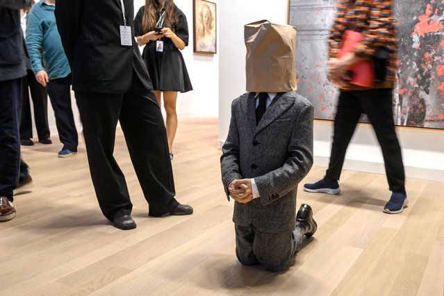 Visitors stand next to the artwork “No, 2021” by Italian visual artist Maurizio Cattelan displayed at the gallery Gagosian during the Art Basel fair for Modern and contemporary art, in Basel, on June 17, 2025. The fair will open to the public from June 19 to June 22, 2025, featuring over 290 leading galleries and more than 4,000 artists from five continents. (Photo by Fabrice Coffrini/AFP Photo)