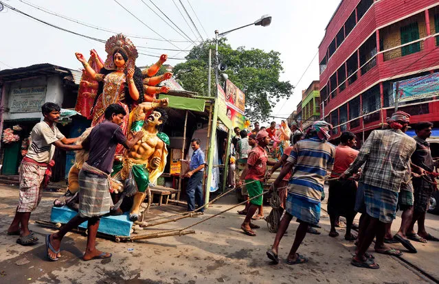 Workers pull an idol of the Hindu goddess Durga through a street towards a pandal, or a temporary platform, ahead of the Durga Puja festival in Kolkata, India, October 5, 2016. (Photo by Rupak De Chowdhuri/Reuters)