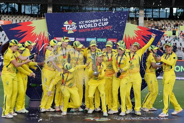 Australia's captain Meg Lanning (C) holds the trophy with her teammates after they won the final T20 women's World Cup cricket match against South Africa at Newlands Stadium in Cape Town on February 26, 2023. (Photo by Marco Longari/AFP Photo)