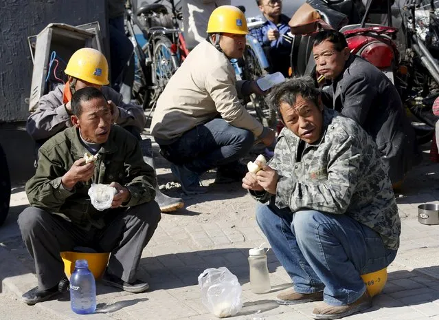 Labourers eat their lunch in front of a construction site at a business district in Beijing, October 29, 2015.  China's Premier Li Keqiang said China requires annual growth of at least 6.53 percent over the next five years, Bloomberg reported, citing unidentified sources. Chinese leaders are meeting in Beijing to decide on an economic growth target for the next five years. (Photo by Kim Kyung-Hoon/Reuters)