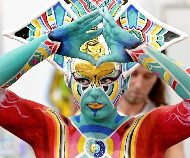 Bodypainter Johannes Stoetter of Italy, works on his model during the 6th Bodypainting Trophy competition at the BEAUTY FORUM and trade fair in Leipzig, on April 13, 2013. (Photo by Jens Meyer/Associated Press)