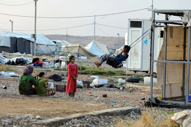 A girl plays on a makeshift swing at Hammam Al-Alil camp where displaced Iraqis prepare to be evacuated, south of Mosul, Iraq on November 10, 2020. (Photo by Abdullah Rashid/Reuters)