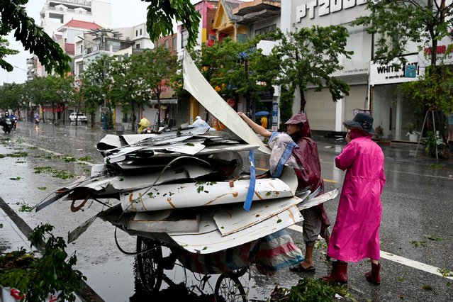 Women clear up corrugated iron sheets that flew onto a road after Typhoon Kajiki passed through Nghe An province on August 26, 2025. Vietnam evacuated tens of thousands of residents from coastal areas on August 25, as Typhoon Kajiki made landfall, lashing the country's central belt with gales of more than 130 kilometres per hour. (Photo by Nhac Nguyen/AFP Photo)