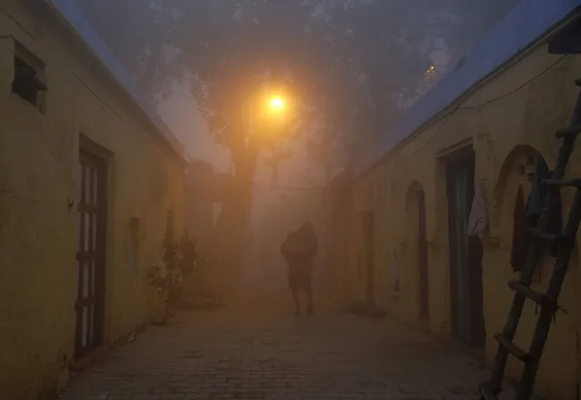 A man walks out of his house in an alley on a cold and foggy morning in New Delhi December 22, 2014. Temperature in New Delhi on Monday dipped to 4.2 degrees Celsius (39.56 degrees Fahrenheit), according to information posted on India's metrological department website. (Photo by Ahmad Masood/Reuters)