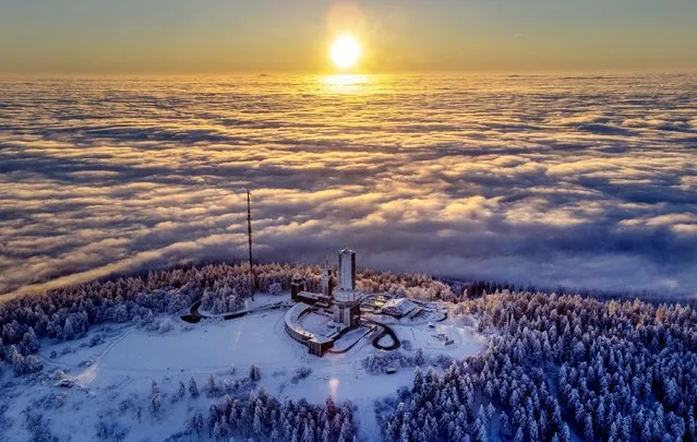 The sun rises over the top the Feldberg mountain while the surrounding is covered by fog near Frankfurt, Germany, Wednesday, January 25, 2023. (Photo by Michael Probst/AP Photo)
