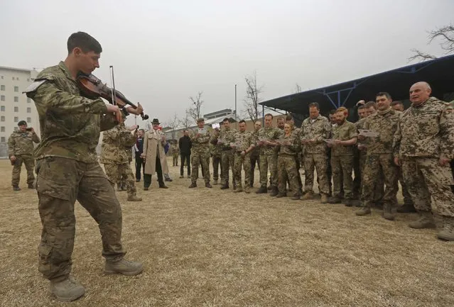 German and British troops sing "Silent Night" before playing a football match to commemorate the Christmas Truce of 1914, at the ISAF Headquarters in Kabul December 24, 2014. (Photo by Omar Sobhani/Reuters)
