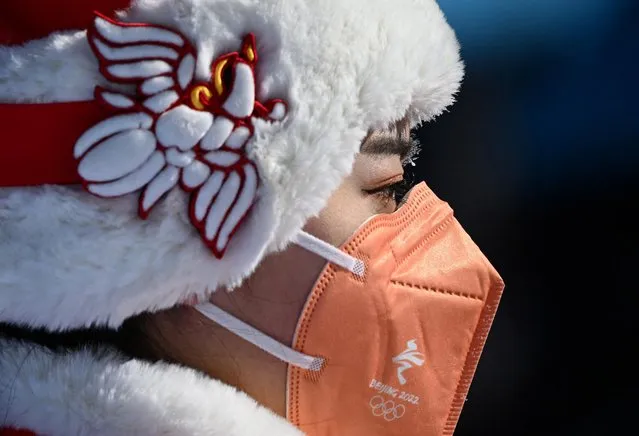 An usher wearing a face mask waits for the start of the medal ceremony after the Men's Freestyle Skiing Freeski Slopestyle Final at Genting Snow Park in Zhangjiakou, China on February 16, 2022. (Photo by Dylan Martinez/Reuters)