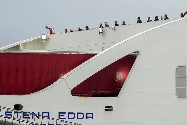 Passengers look out from Stena Line's Irish sea ferry Stena Edda at the company's River Mersey Birkenhead terminal after 322 passengers were stranded on the ferry overnight after crew members tested positive for Covid-19 on December 16, 2020 in Birkenhead, England. The 322 passengers and 53 crew have been told by public health authorities to disembark. (Photo by Christopher Furlong/Getty Images)
