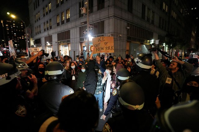 Police officers stand infront of people protesting outside 26 Federal Plaza (Jacob K. Javits Federal Building), where migrants who were detained during a raid in Lower Manhattan by U.S. Immigration and Customs Enforcement (ICE) were brought in, in Manhattan, New York, U.S., October 21, 2025. (Photo by David Dee Delgado/Reuters)