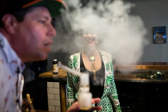 Elise McRoberts smiles as a customer exhales after using a full spectrum oil vaporizer at the new Magnolia cannabis vape lounge in Oakland, California, U.S. April 20, 2018. Friday marked the first “4/20” since the sale of recreational marijuana became legal on January 1. (Photo by Elijah Nouvelage/Reuters)