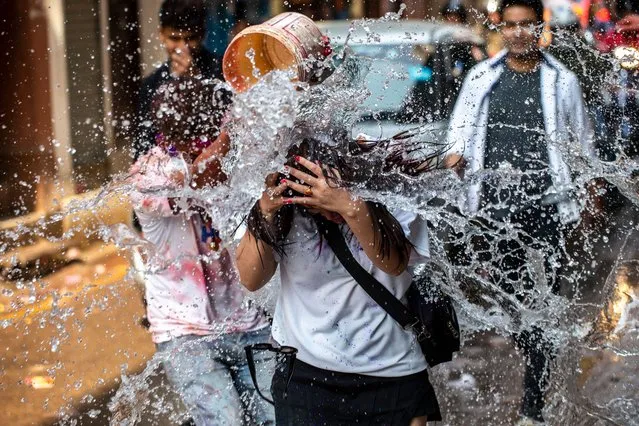 A young man throws water on pedestrians during the Holi Festival in Kathmandu, Nepal, 06 March 2023. Holi, also known as the 'Festival of Colors', marks the beginning of spring and is celebrated all over Nepal and neighboring India. (Photo by Narendra Shrestha/EPA/EFE/Rex Features/Shutterstock)