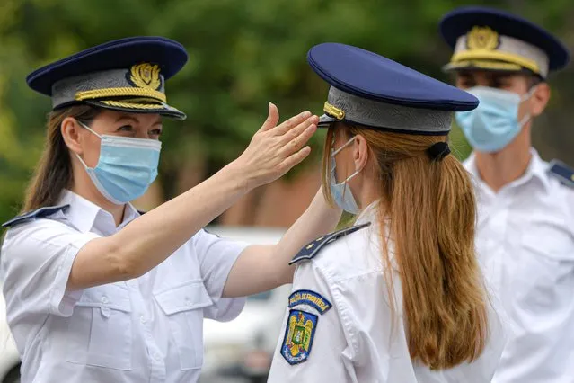 Border guard officers, wearing masks against COVID-19 infection adjust their outfits before a distinguished service awards ceremony for employees of the interior ministry in Bucharest, Romania, Thursday, July 16, 2020. Romania has registered on Thursday the highest number of COVID-19 infection cases since the pandemic reached the country in February, 777 in a 24 hours interval, as many fail to observe the mandatory protection measures, like the use of a face mask indoors or maintaining social distancing. (Photo by Andreea Alexandru/AP Photo)