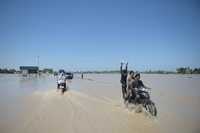 Motorists ride on a flooded street in Pidie Jaya, Aceh province, Indonesia, Saturday, November 29, 2025. (Photo by Reza Saifullah/AP Photo)