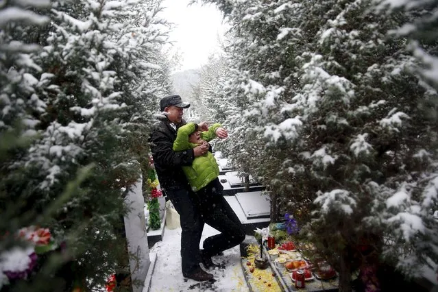 Fan Guohui comforts his wife Zheng Qing as they show their son's resting place to reporters on their visit to the graveyard in Zhangjiakou, China, November 22, 2015. Fan Lifeng, the son of Fan Guohui and his wife Zheng Qing, both aged 56, was born in 1984 and died in a car accident in 2012. (Photo by Kim Kyung-Hoon/Reuters)