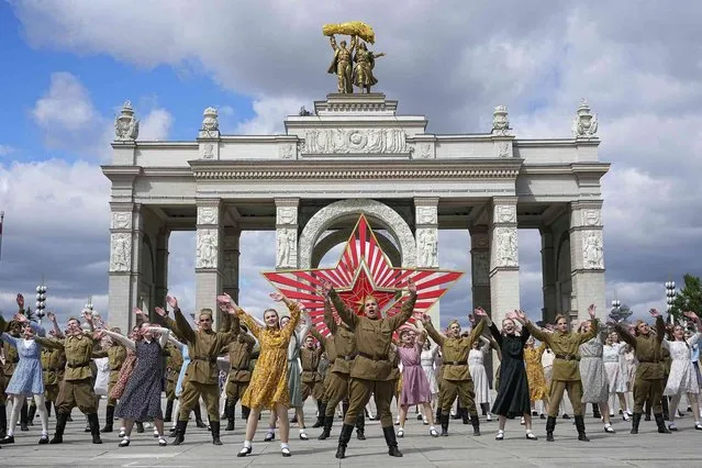 Moscow students dressed in the fashion of the middle of the last century and Soviet style uniform perform “Victory Waltz” as a part of Victory Day celebration in front of the historical main gates of VDNKh, The Exhibition of Achievements of National Economy, with the red star in the background in Moscow, Russia, Saturday, May 6, 2023. Russia will celebrate 78th years of the victory in WWII on Tuesday, May 9. (Photo by Alexander Zemlianichenko/AP Photo)